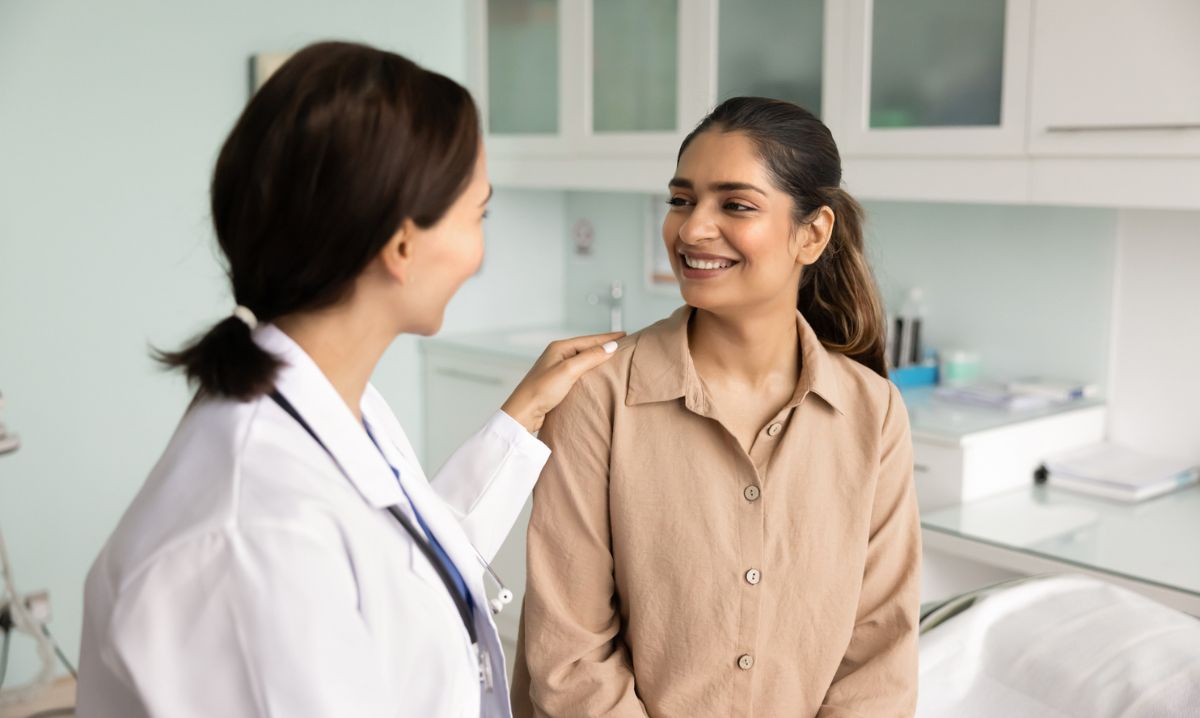 A physician consulting with a woman in a clinical setting, illustrating the Zero Suicide model as an integrated element of health care.